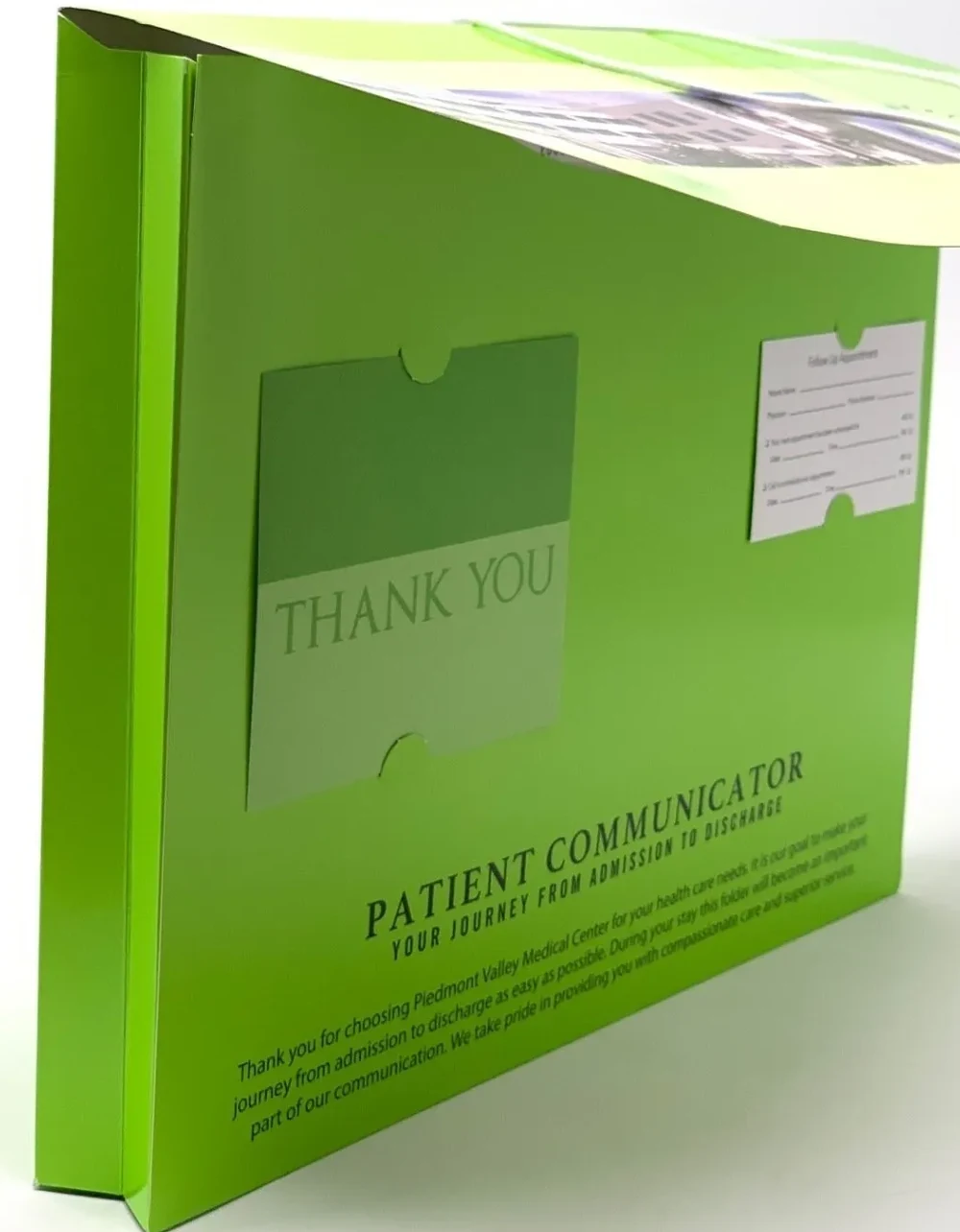 A TPC admit and discharge folder standing upright, showing its printed cover message, a thank-you card pocket and a follow-up appointment card