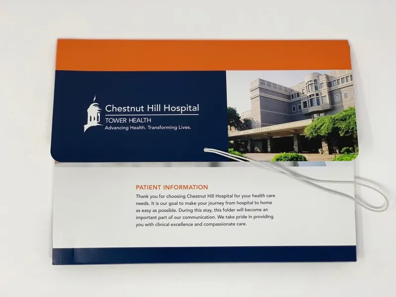 Chestnut Hill Hospital folder standing closed, printed with the hospital exterior and a patient information message