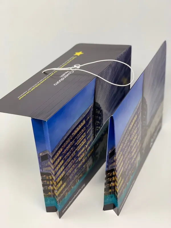 Owensboro Health folder opened from above, showing the printed panels and the elastic loop closure